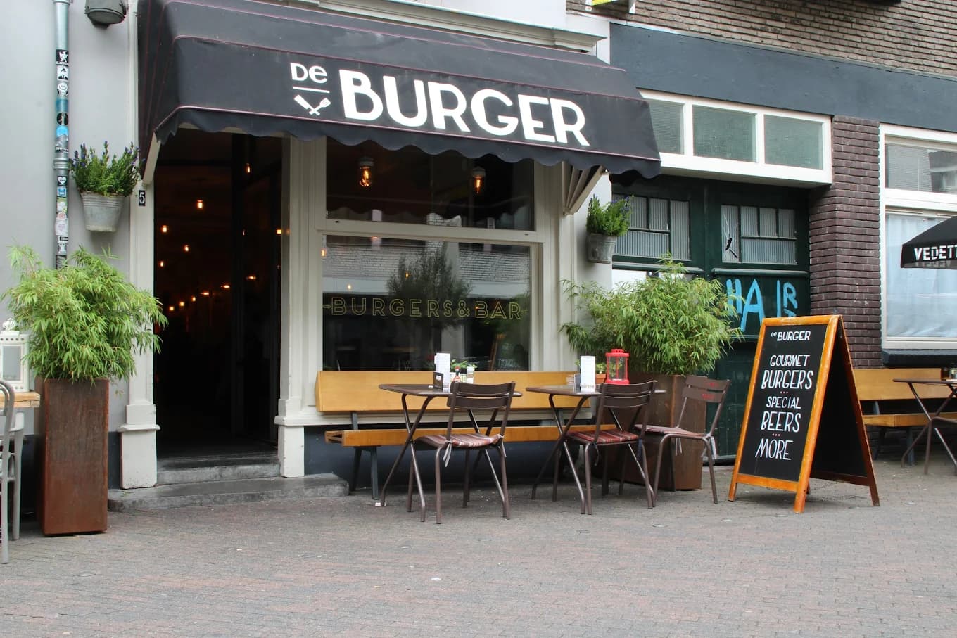 Gevel van De Burger in Eindhoven met zwarte luifel en terras