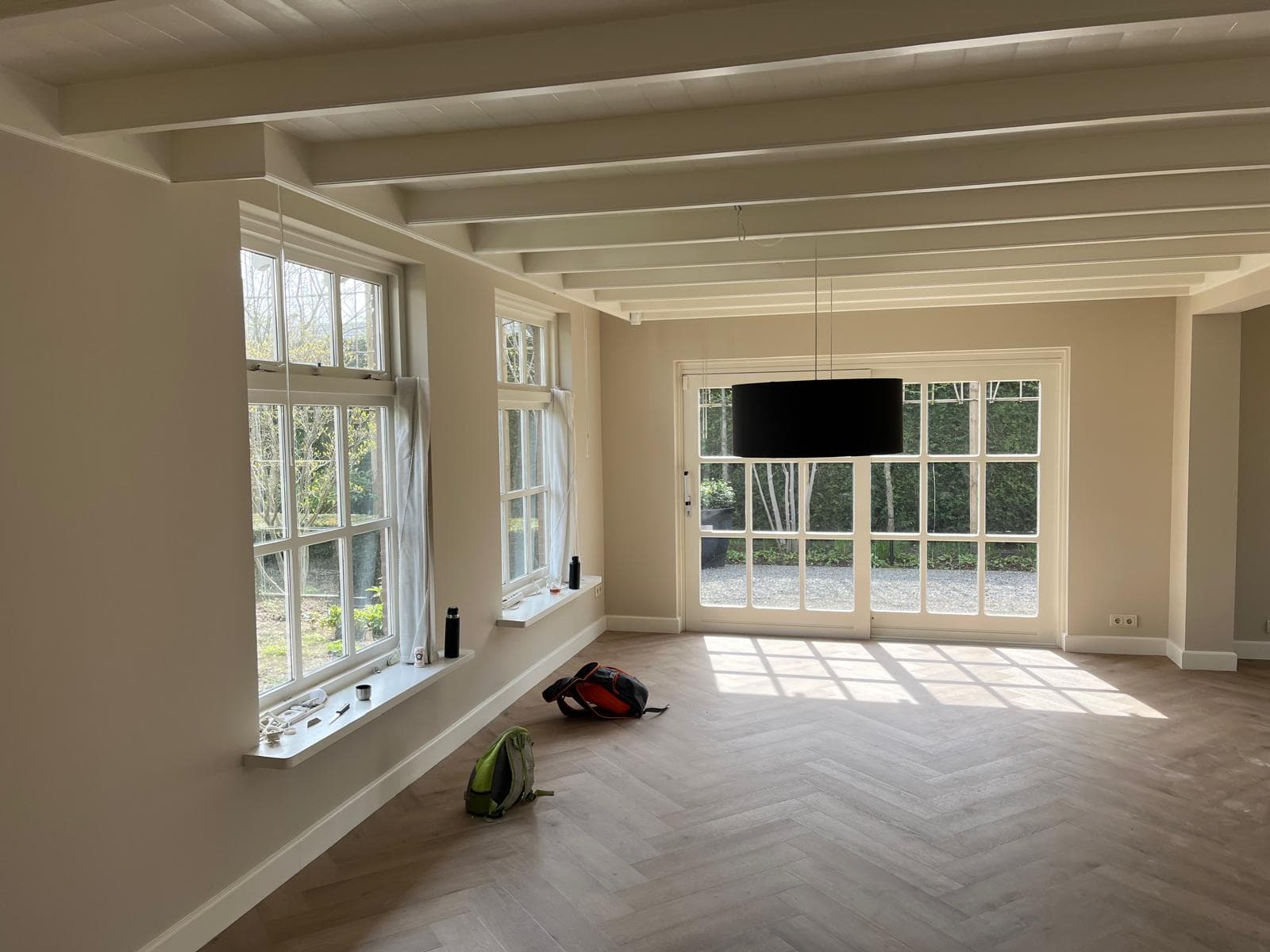 Kamer met geschilderd balkenplafond en witte kozijnen tijdens de oplevering