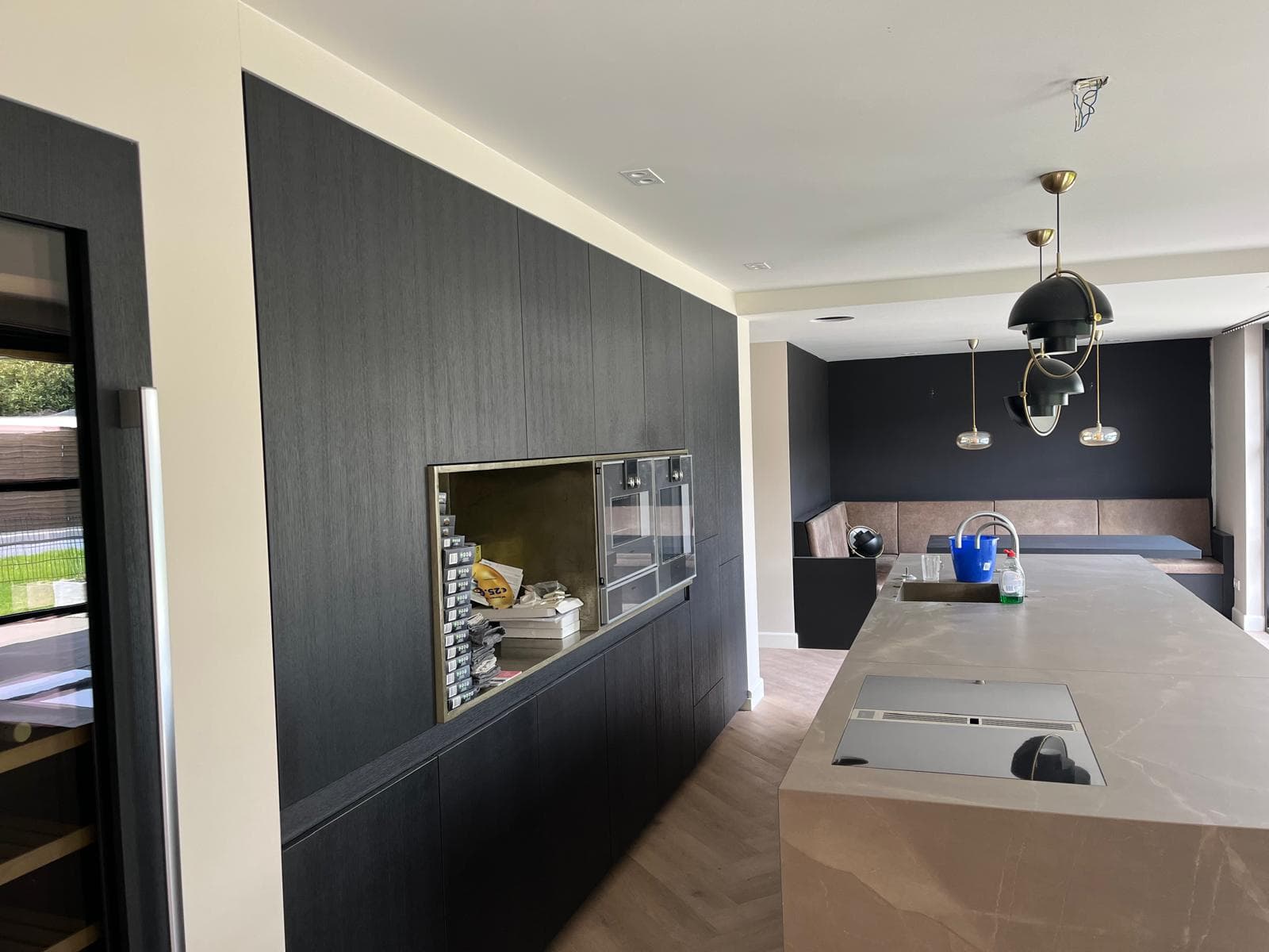 Keuken met strak geschilderde wanden en plafond naast een donkere wandkast
