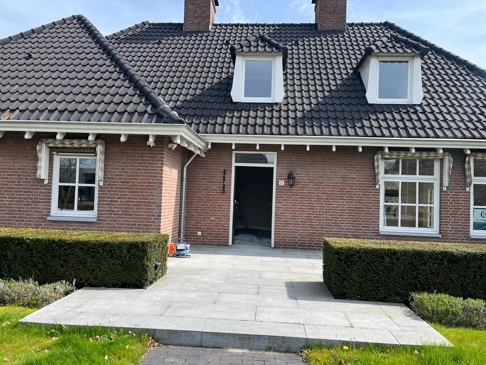 Voorgevel van de vrijstaande woning met wit geschilderde kozijnen, dakkapellen en gootlijsten